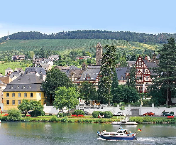A yacht sails by the town of Traben-Trarbach, Germany along the Mosel River