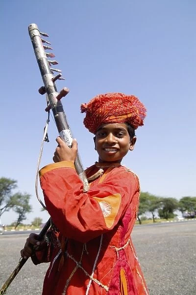 Young boy aged 10 with musical instrument called Sarangi on road to Jodhpur in Rajasthan India