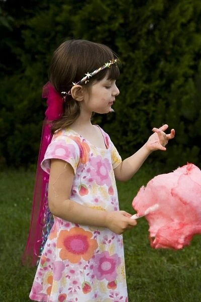 A young girl (age 5) enjoys cotton candy at the Quechee Balloon Festival, Quechee, Vermont