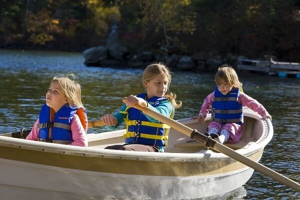 Three young girls (ages 3, 5, 9) in a row boat at Oliver Lodge on Lake Winnipesauke in Meredith