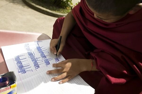 Young monk practicing calligraphy, Dharamsala, India