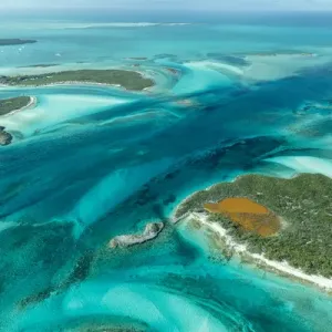 Aerial photo looking down at the clear tropical water and islands in the Exuma Chain