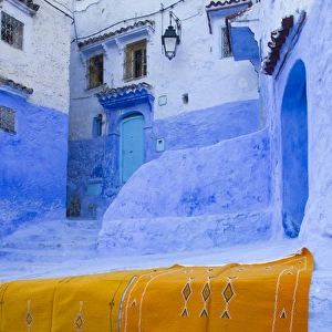 Africa, Morocco, Chefchaouen. Rugs draped on a wall in the blue town