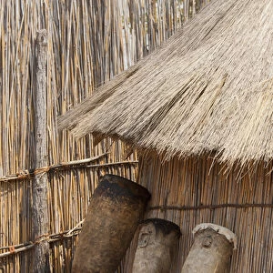 Africa, Namibia, Caprivi Strip. Tribal drums lean on grass hut in Mbukushu Tribe village