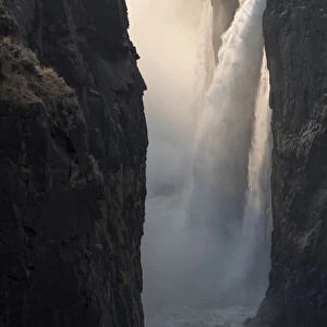 Africa, Zimbabwe, Victoria Falls. Close-up of waterfall and spray at sunrise. Credit as