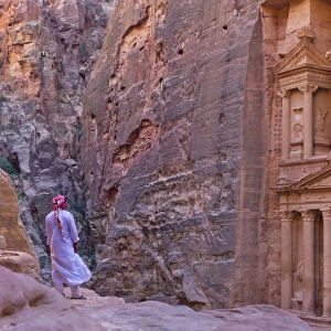 Arab man watching Facade of Treasury (Al Khazneh), Petra, Jordan (UNESCO World Heritage