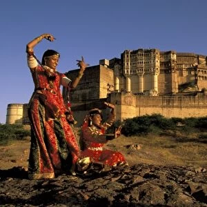 Asia, India, Jodhpur. Two women dancing in front of Meherangarh Fort. MR