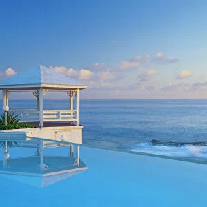 Bahamas, Long Island, Gazebo reflecting on pool with sea in background