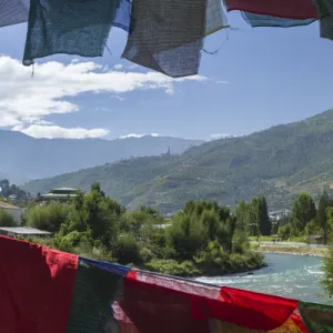 Bhutan, Punakha. Prayer flags line the cantilever bridge over the Mo Cchu river at