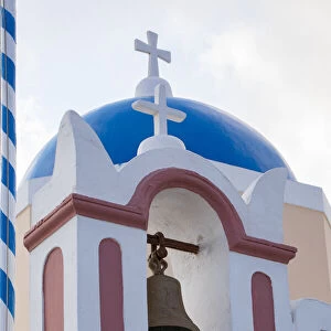 Blue domed Greek Orthodox church with bell in Oia, Santorini, Greece