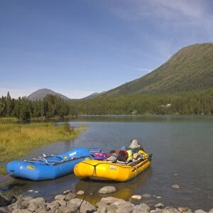 A blue and a yellow rubber raft on the Kenai River along the Sterling Highway in Alaska