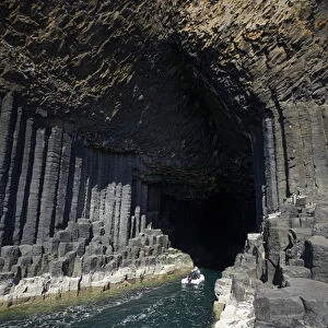 Boat at entrance to Fingals Cave, Staffa, off Isle of Mull, Scotland, United Kingdom