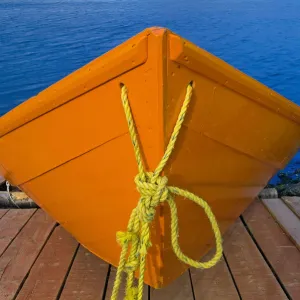 Canada, Newfoundland, Frenchman Cove. Orange boat on dock