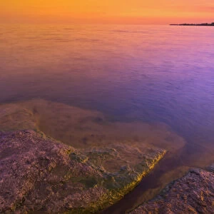 Canada, Ontario, Selkirk. Morning light on rocky shoreline of Lake Erie