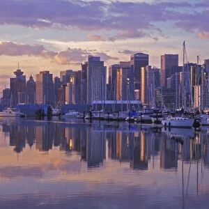 Canada, Vancouver, British Columbia. Vancouver Skyline with boats in harbor at sunrise