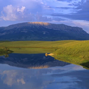Castle Reef reflects into the Pishkun Canal along the Rocky Mountain Front in Montana