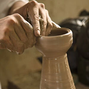 Central America, Nicaragua, Catarina. Potters hands creating clay pottery on spinning wheel