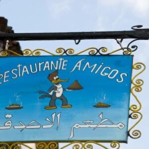 Chefchaouen Morocco restaurant Amigos sign with woodpecker holding a tagine