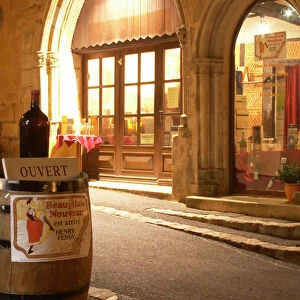 Cobble stone street in the old town with a wine shop, a wine barrel on the street