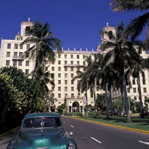 Cuba, Havana. Classic 1950s auto in front of Habana Nacional Hotel