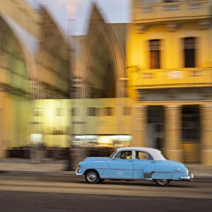 Cuba, Havana, classic car in motion at dusk on Malecon