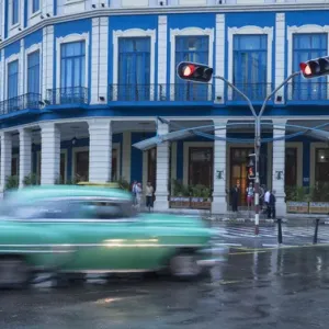 Cuba, Havana. A classic car passes by in a rainstorm the city Cuba, Havana. A classic car passes by in a rainstorm the city
