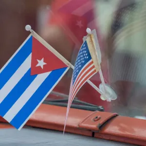 Cuba, Havana, Havana Vieja (Old Havana), Cuban and US flags on dashboard of car