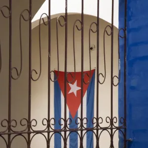 Cuba, Vinales, Cuban flag in courtyard and wrought iron gate