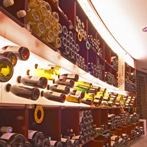 A curved display of bottles. Backlit The Lavinia wine shop in Paris. Probably the