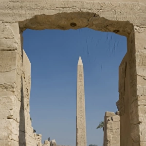 Egypt, Luxor. The obelisk at Karnak Temple rises tall above visitors to the ancient ruins