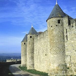Europe, France, Carcassonne. Shadows of the crenelatted walls shade the pathway under