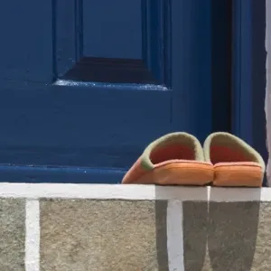 Europe, Greece, Mykonos, Hora. Orange slippers on threshold of blue door. Credit as Europe, Greece, Mykonos, Hora. Orange slippers on threshold of blue door. Credit as