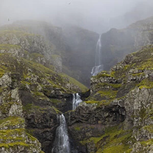 Europe, Iceland. Thin waterfall cascades down a mountainside in southern Iceland