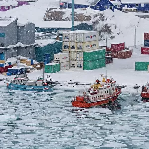 Fishing boats in the frozen harbor during a snow storm. Ilulissat, Greenland. (Editorial Use Only)