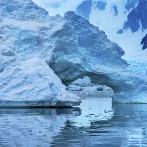 Floating blue iceberg arch reflection, Paradise Bay, Skontorp Cove, Antarctica