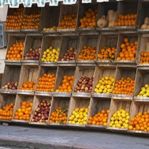 A fruit and vegetable shop displaying products in wooden crates on the street: tomatoes