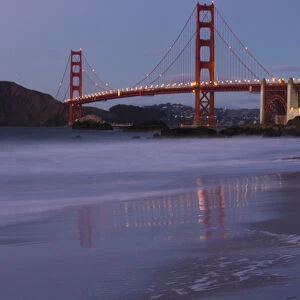 The Golden Gate Bridget at dusk reflected in the sands of Baker Beach, San Francisco
