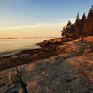 Granite shoreline of Rockport Harbor at sunrise, Rockport, Maine