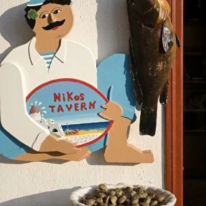 Greece, Mykonos, Hora. Sign at entrance to Nikos Tavern beside hanging fish