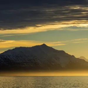Greenland. Kong Oscar Fjord. Sunset over the calm water of the fjord Greenland. Kong Oscar Fjord. Sunset over the calm water of the fjord