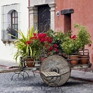 Guatemala, Antigua. An old wooden cart filled with flowers on the streets of Antigua