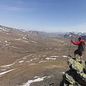 A hiker looks across the upper Nigu River Valley in Gates of the Arctic National Park and Preserve