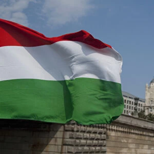 Hungary, capital city of Budapest. Hungarian flag in front of historic building