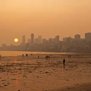 L'Inde, Maharashtra, Mumbai, la plage de Chowpatty, coucher du soleil avec un soleil rouge descendant. L'Inde, Maharashtra, Mumbai, la plage de Chowpatty, coucher du soleil avec un soleil rouge descendant.