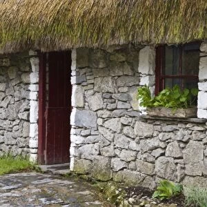 Ireland, Bunratty, County Clare. Traditional thatch and stone cottage in Bunratty Castle