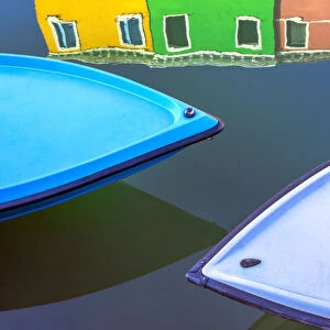 Italy, Burano. Boat bows and house reflection in canal