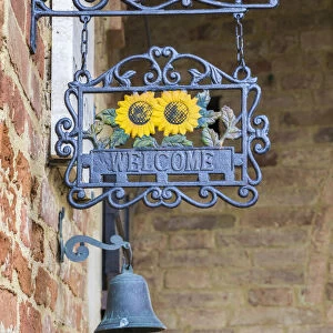 Italy, Tuscany. A wrought iron welcome sign in the village of Chiusure in the province of