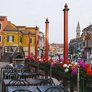 Italy, Venice, Burano. Cafe tables along the canal