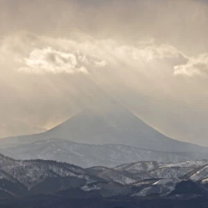 Japan, Hokkaido, Tsurui. God rays shine over mountain