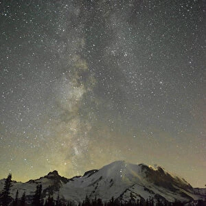 The lights of climbers can be seen on the mountain as the Milky Way rises behind Mt